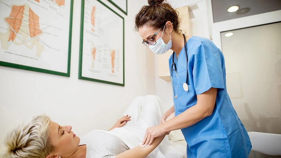 イメージ写真：メガネをかけた看護師が患者の介助を行う様子